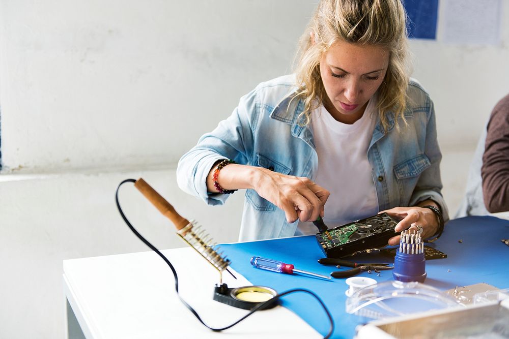 Caucasian technician woman using screw driver install a screw to HDD