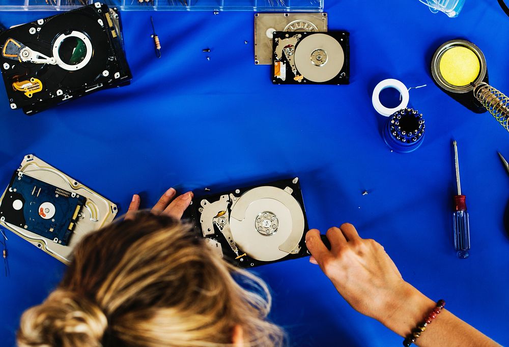 Caucasian technician fixing HDD at workstation