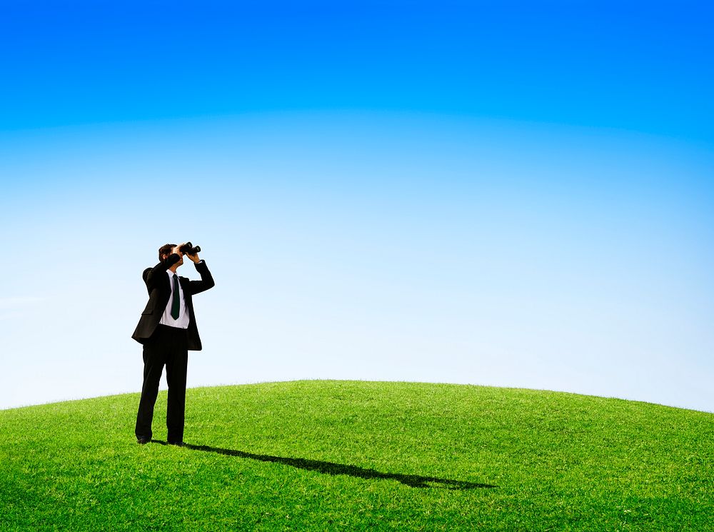 Business man observing nature with a telescope outdoors.