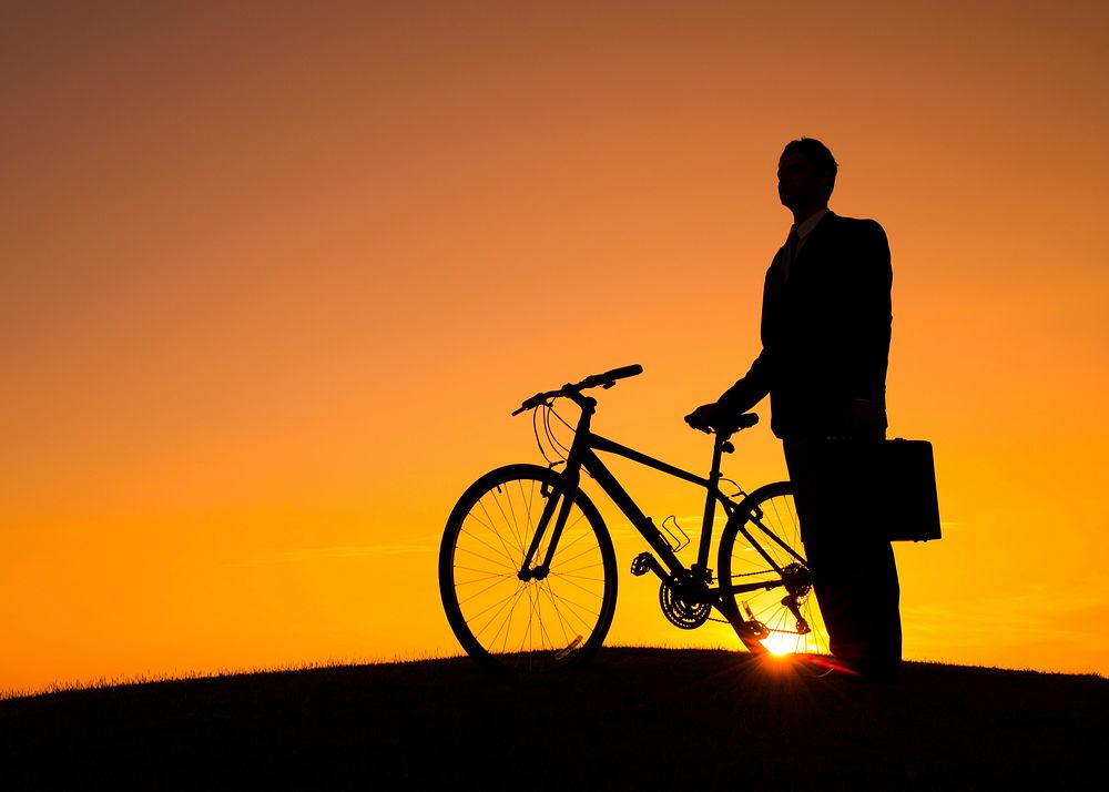 Silhouette of a businessman with his bike