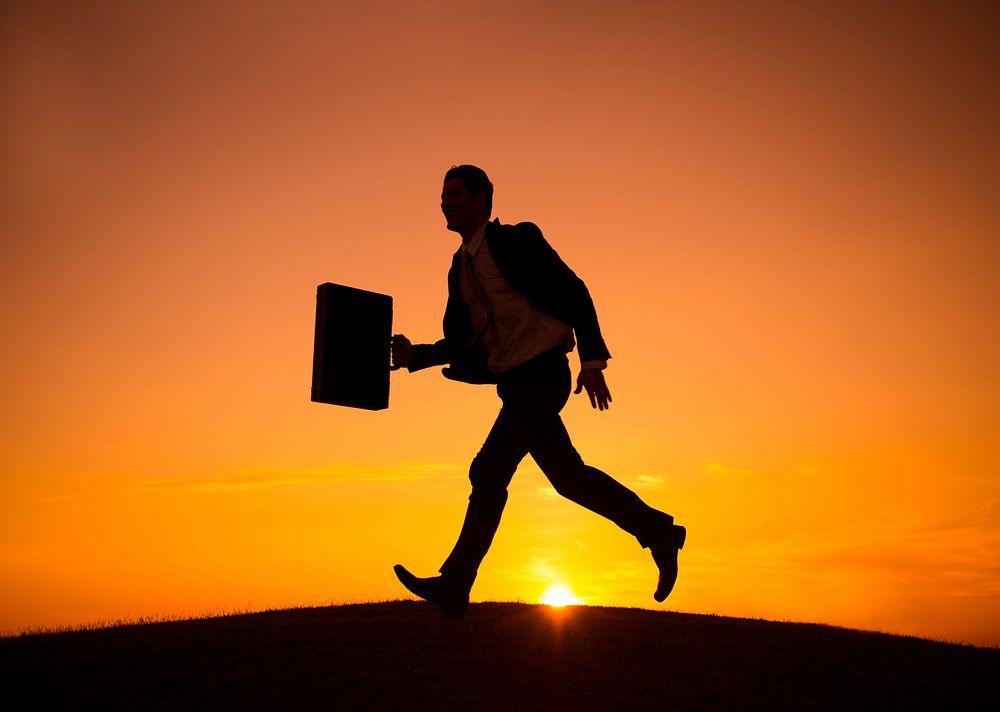 Silhouette of a businessman walking in a hurry