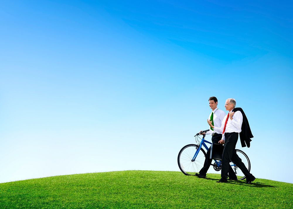 Business Men Walking Through the Field with a Bicycle