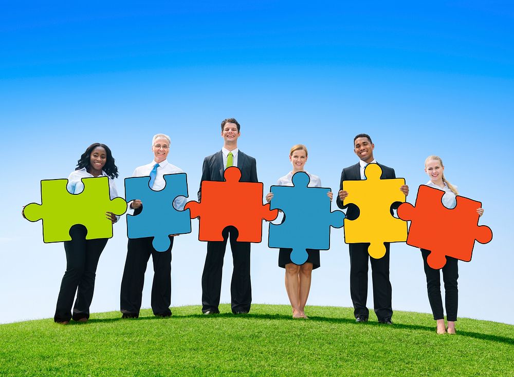 Business People Holding Jigsaw Puzzle Pieces Outdoors