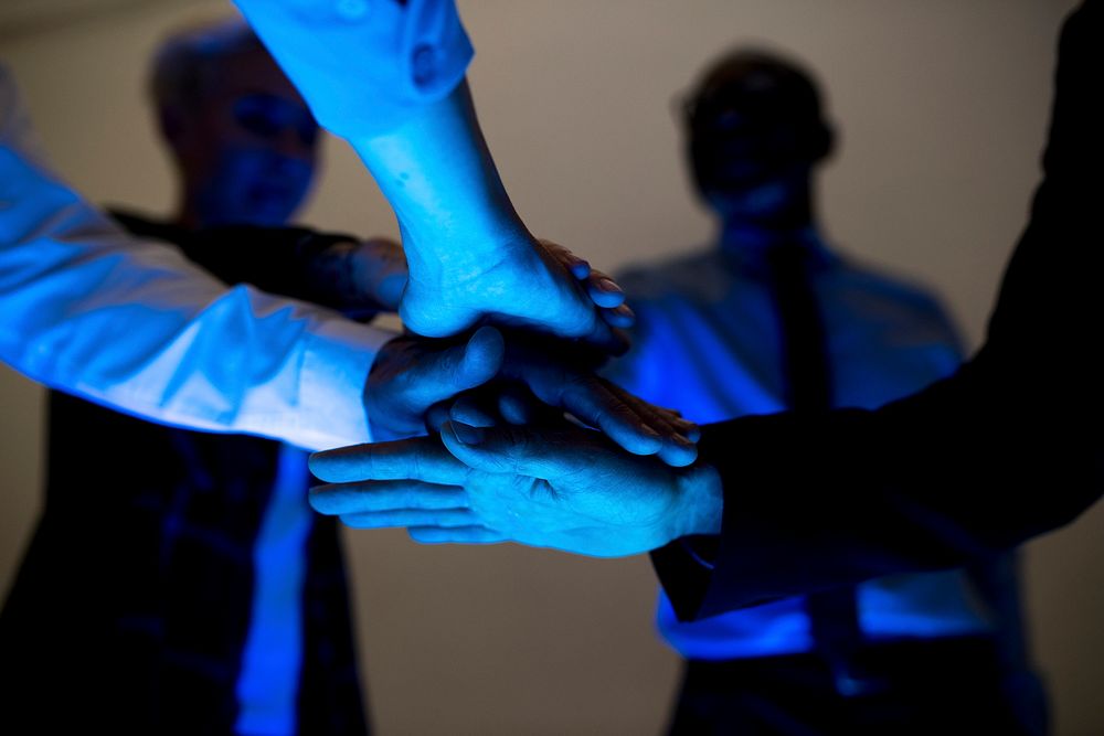 Hands join together in a group meeting