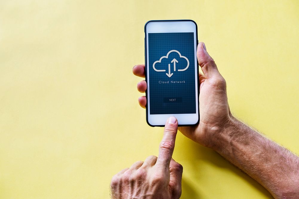 Hands holding a smartphone with cloud network on screen
