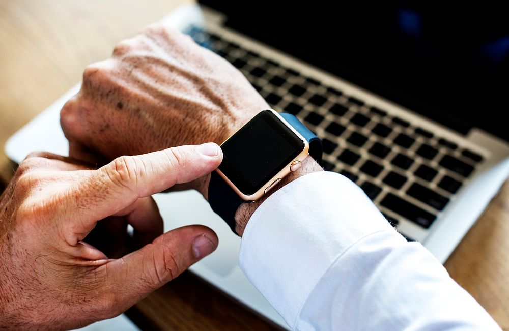 Hand setting a smartwatch on another hand