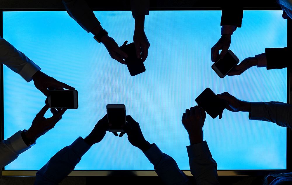 Group of silhouette hands holding smartphone