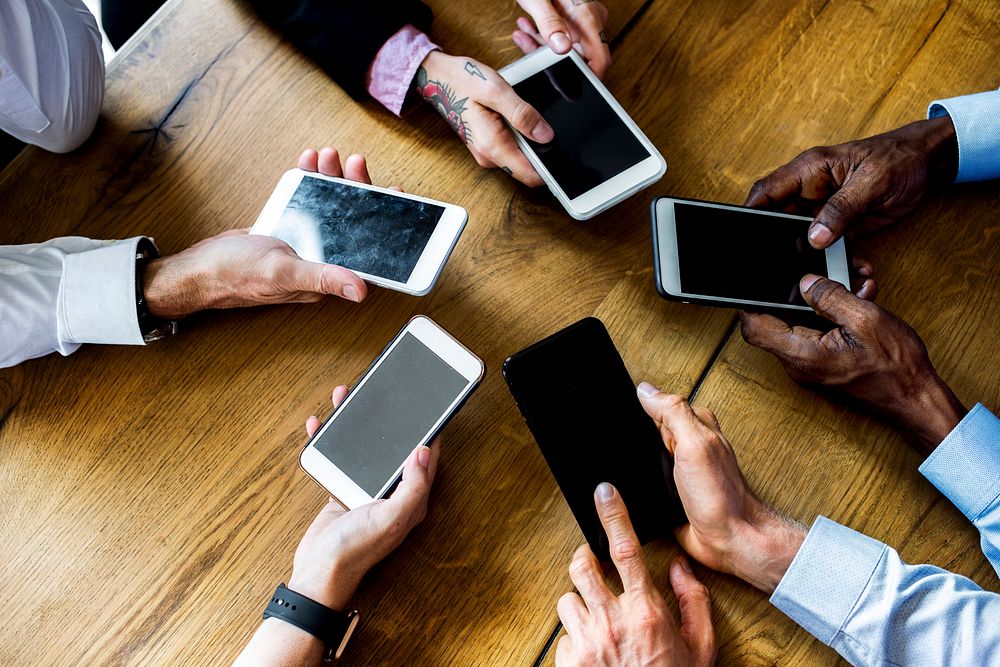 People hands using smartphone gadget in a meeting