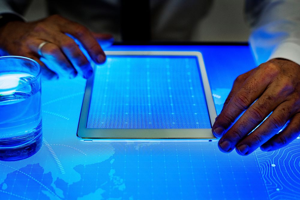 Hands on digital tablet on cyber space table