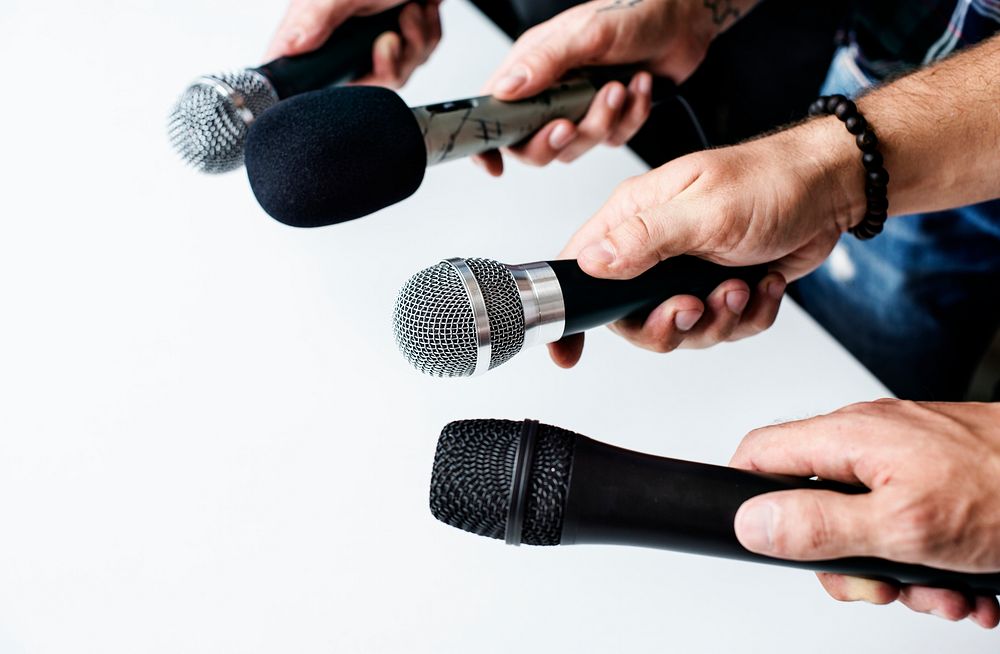 Hands holding microphone point to the same direction