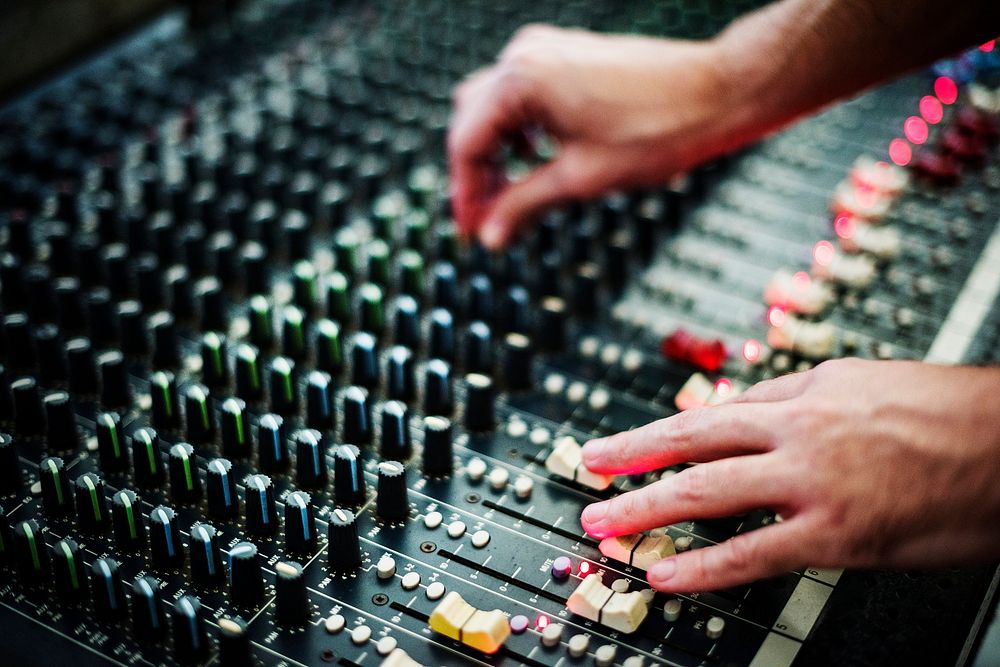 Hands on a sound mixer station