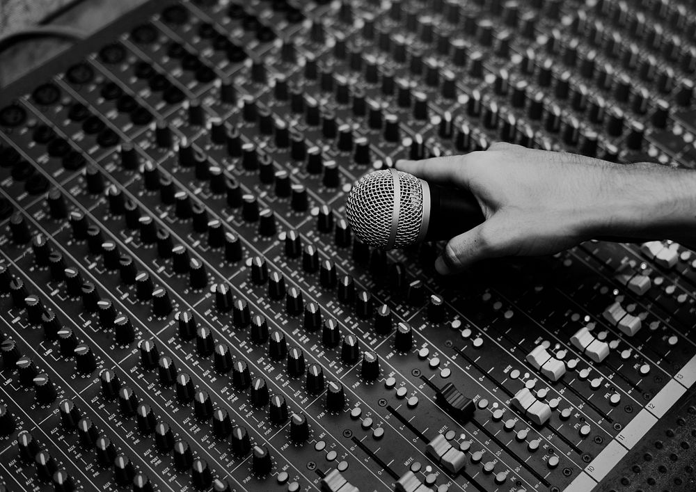 Hand with microphone on a sound mixer grayscale