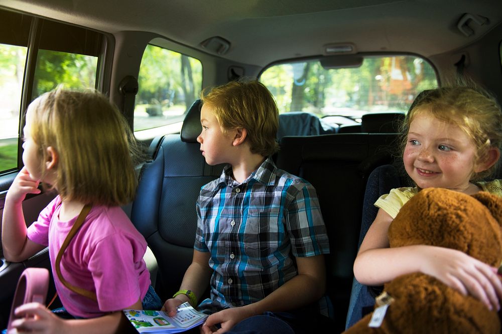 Caucasian siblings enjoying the car ride