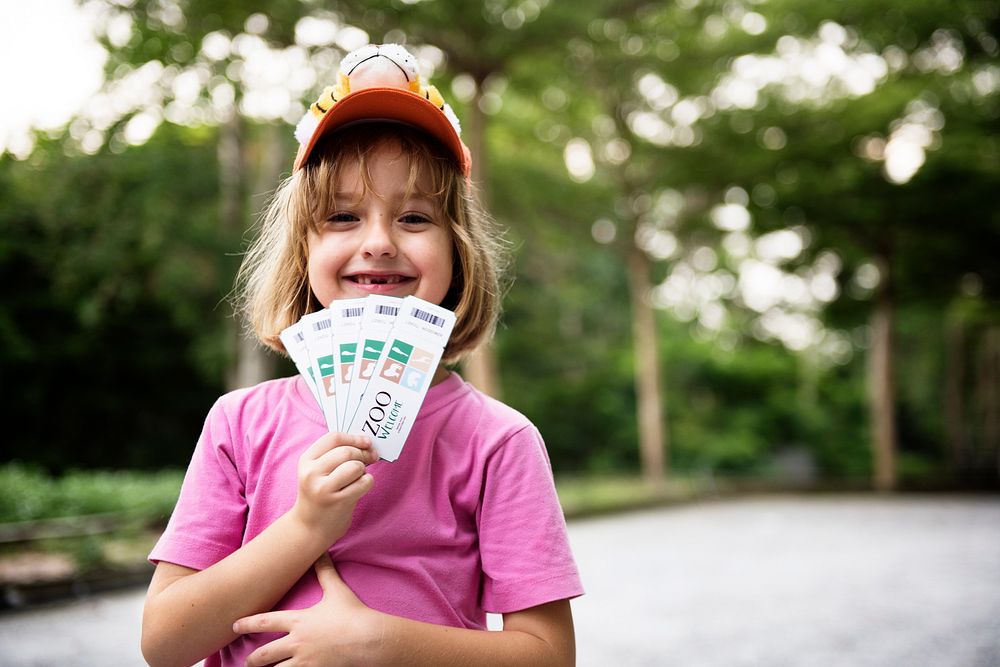Closeup of young caucasian girl showing zoo tickets