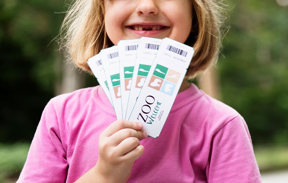 Closeup of young caucasian girl showing zoo tickets
