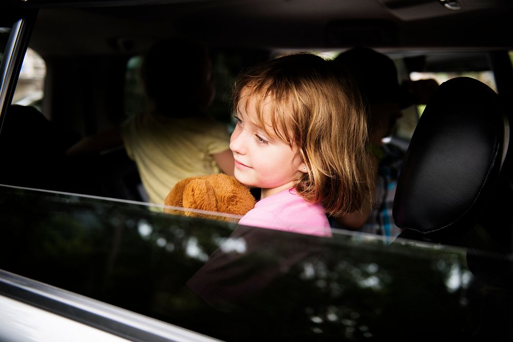 Young caucasian girl sit inside the car open window