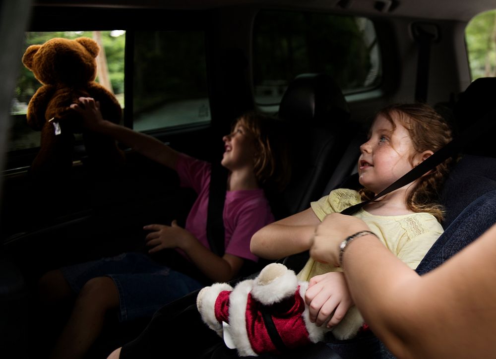 Young girls sitting inside a car