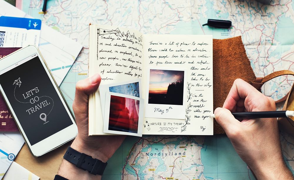 Closeup of hands holding journey diary notebook over map background