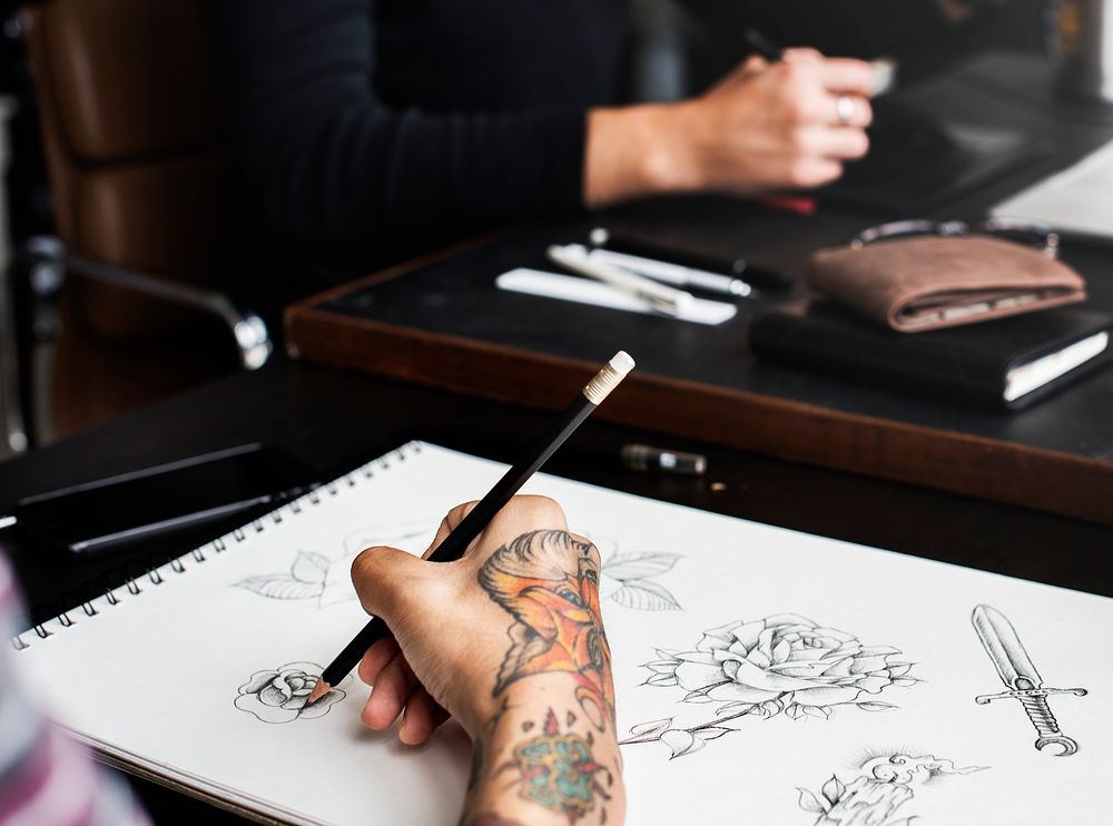 Closeup of tattooed hand with drawing artwork