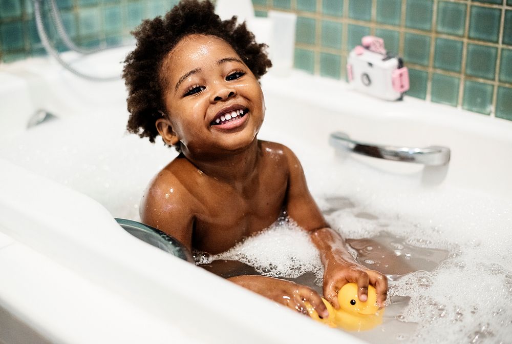 African descent kid enjoying bath tub