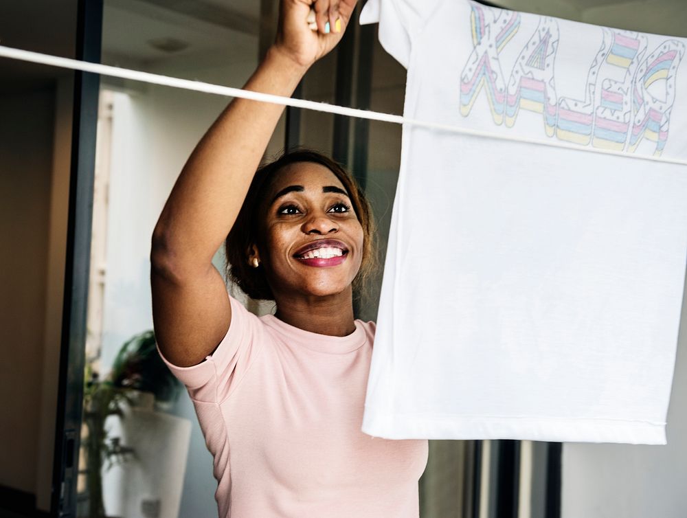 Closehup of black woman hanging washed clothes housework