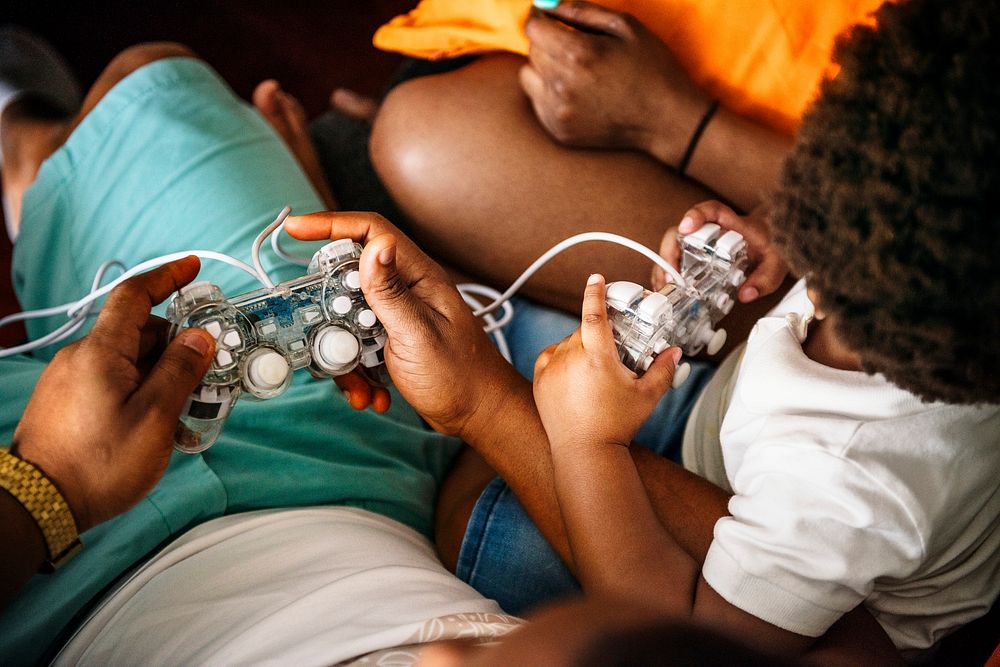 Black family playing game console together