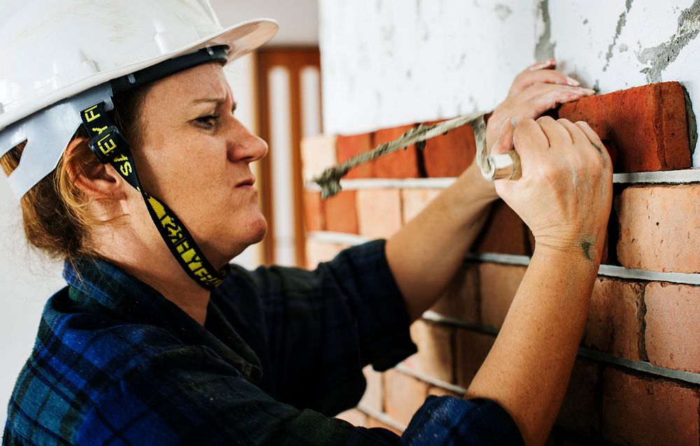 Woman construction repair plastering on the wall