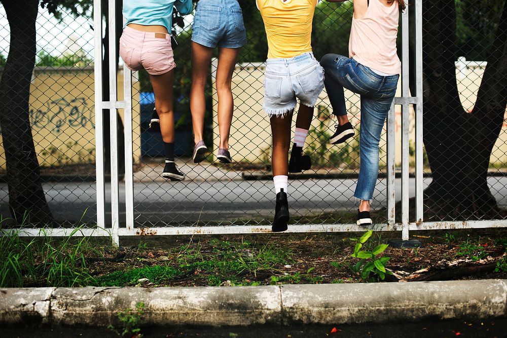 Group of women climbing the fence