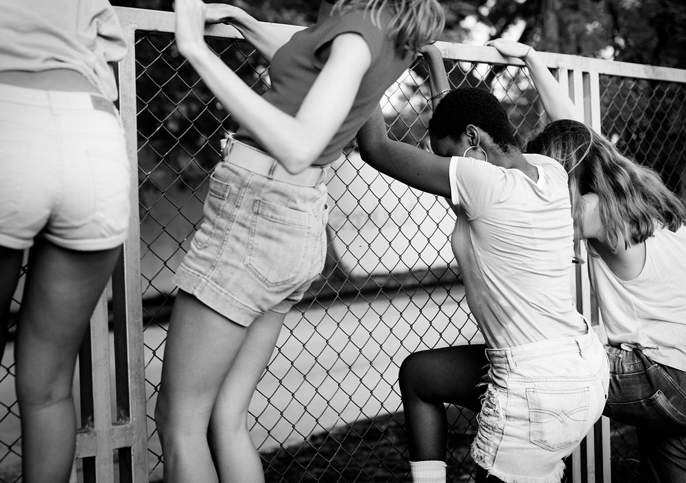 Group of women climbing over the fence