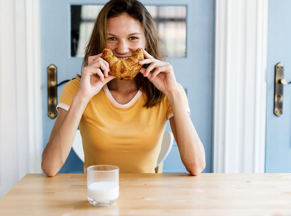 Caucasian woman with croissant as smiling
