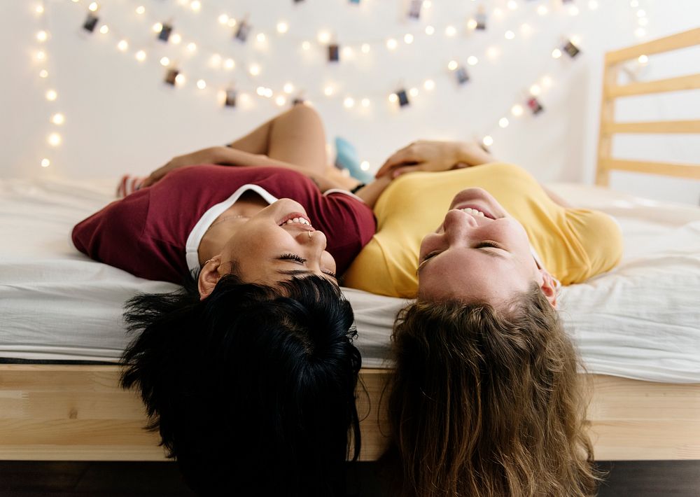 Women lying on the bed and laughing