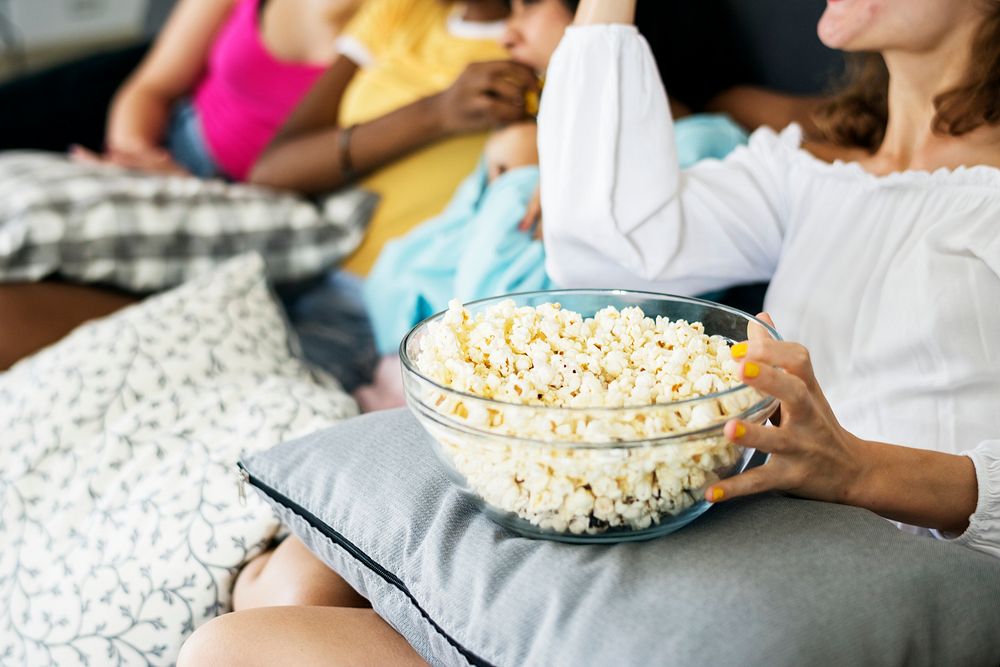 Diverse women eating popcorn together