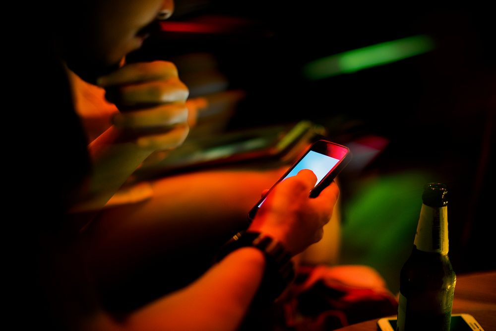 Closeup of people using mobile phone night time