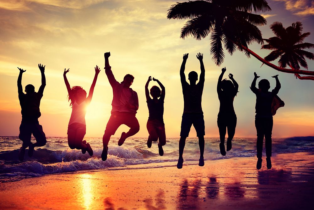 Young People Jumping with Excitement on the Beach