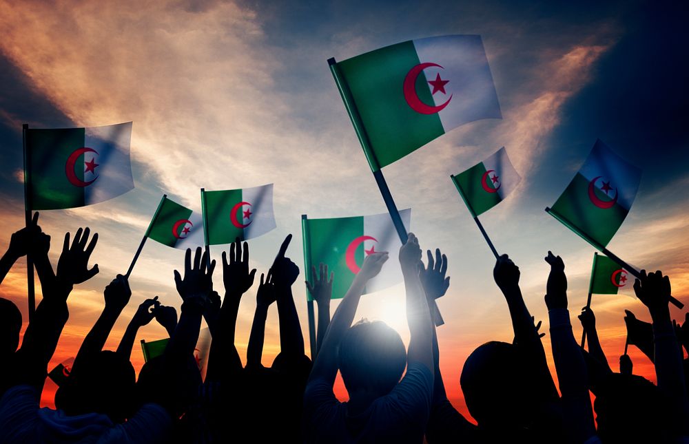 Silhouettes of People Holding Flag of Algeria
