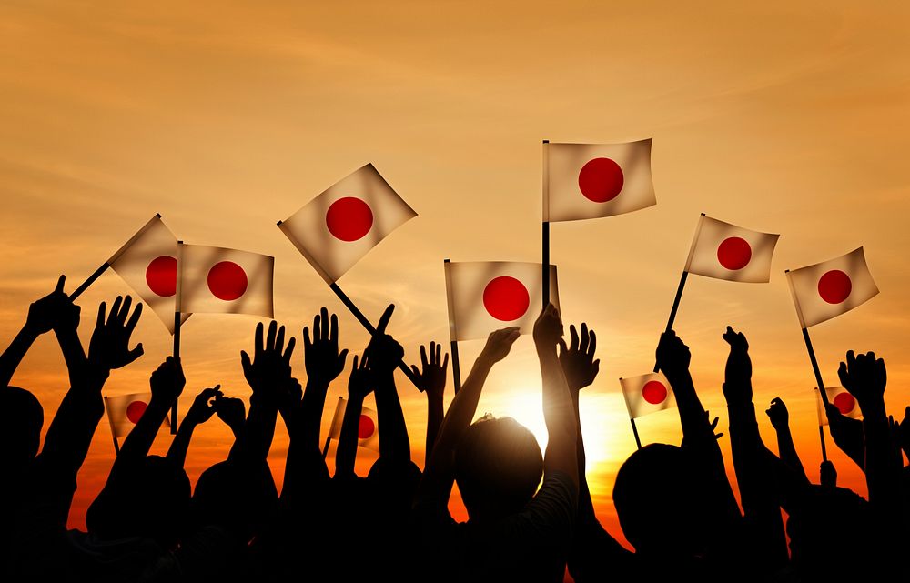 Silhouettes of People Holding the Flag of Japan