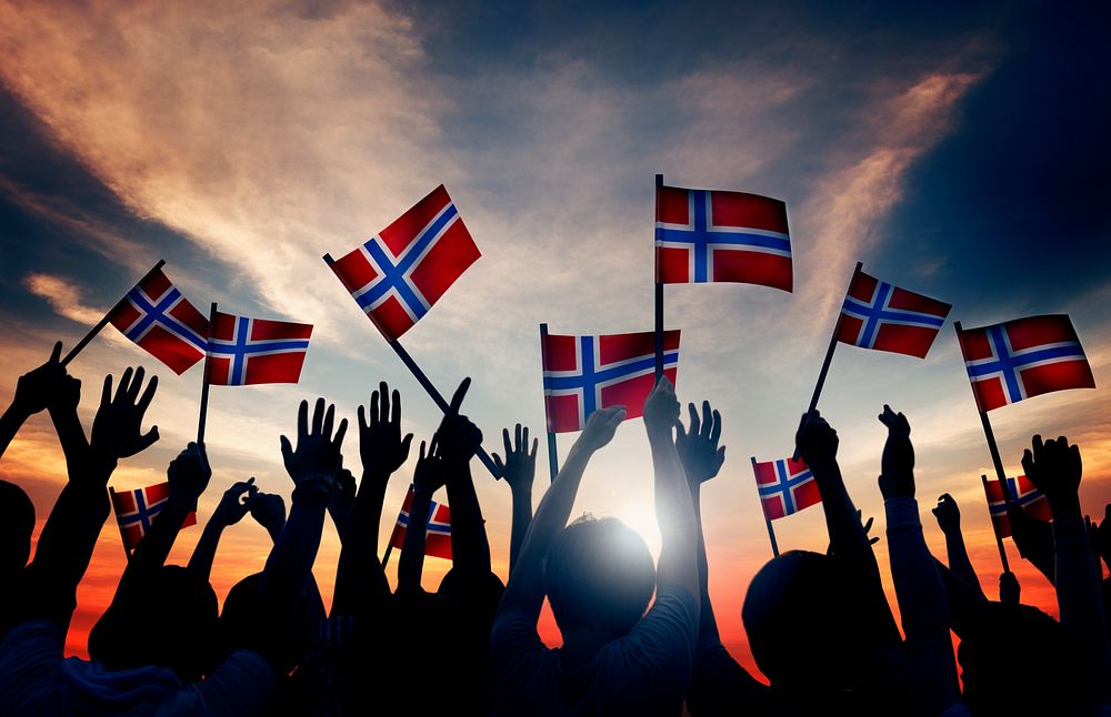 Group of People Waving Norwegian Flags in Back Lit
