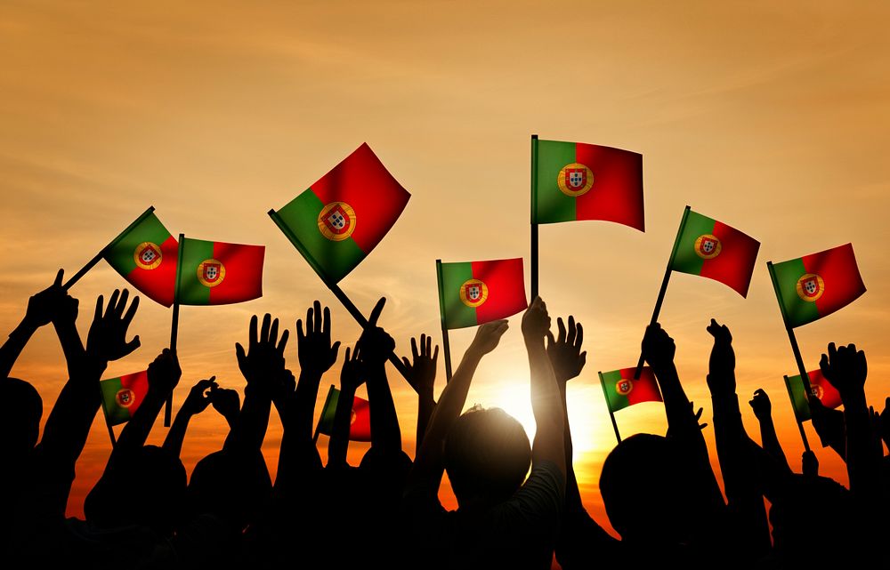 Group of People Waving Portuguese Flags in Back Lit