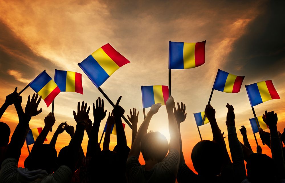 Group of People Waving Romanian Flags in Back Lit