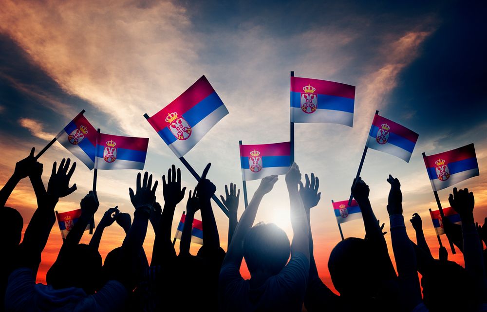 Group of People Waving Flag of Serbia in Back Lit