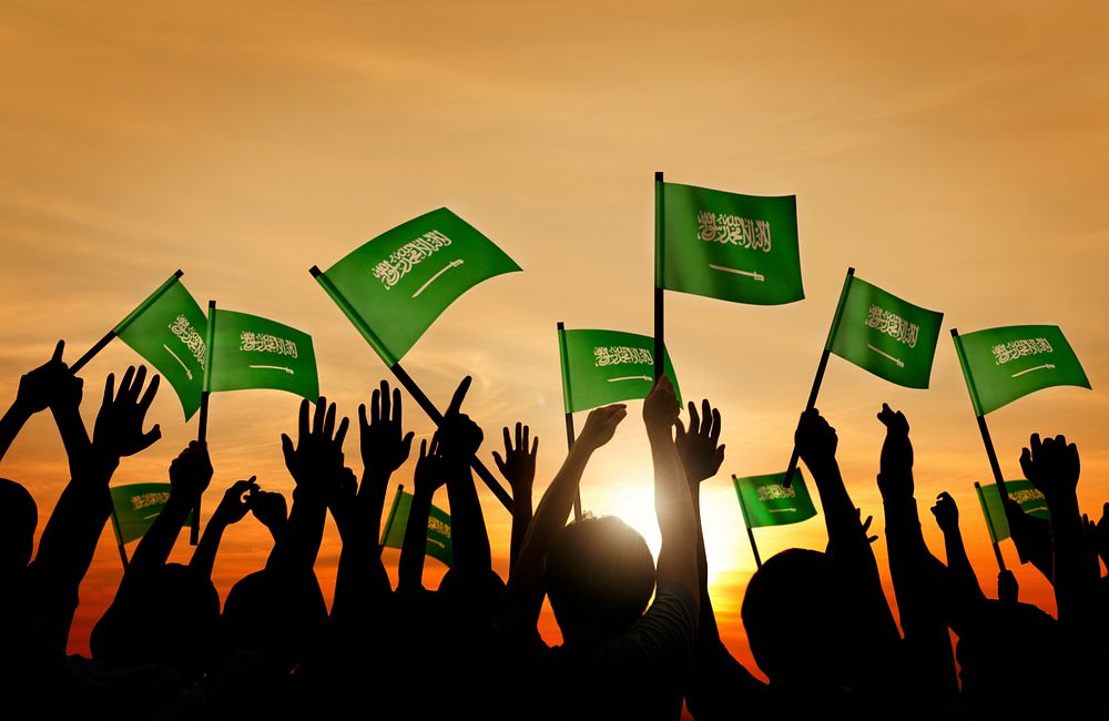 Silhouettes of People Holding Flag of Saudi Arabia
