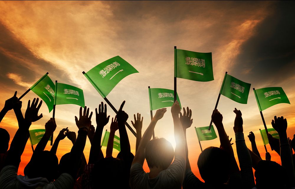 Silhouettes of People Holding Flag of Saudi Arabia