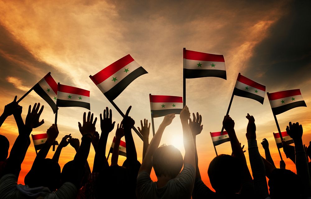 Group of People Waving Flag of Syria in Back Lit