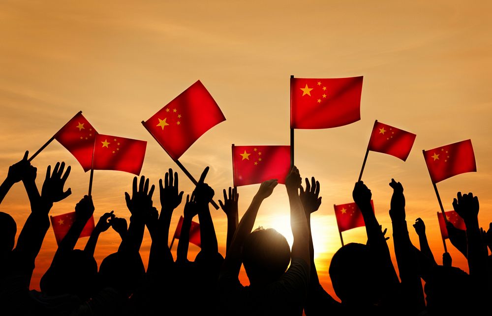Silhouettes of People Holding the Flag of China