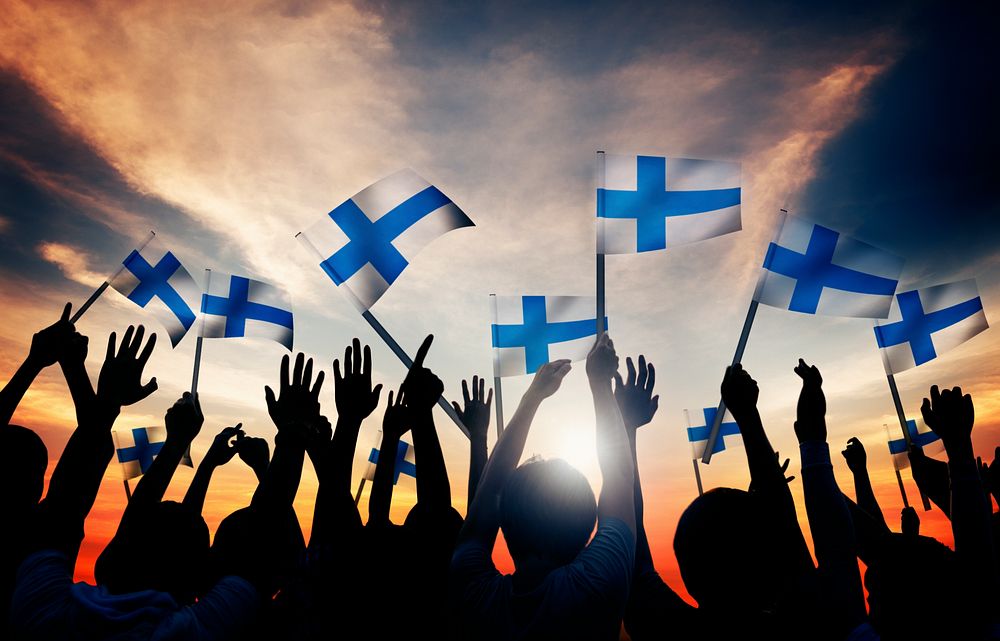 Silhouettes of People Holding the Flag of Finland