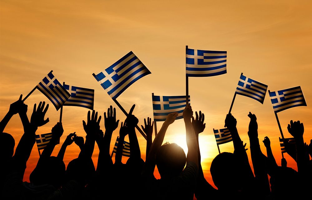 Silhouettes of People Holding the Flag of Greece