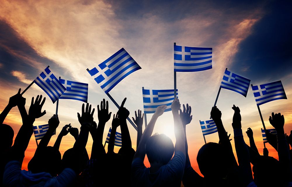 Silhouettes of People Holding the Flag of Greece