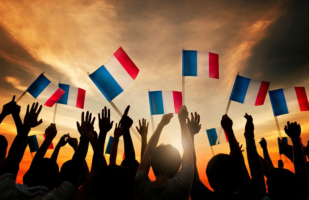 Group of People Waving French Flags in Back Lit