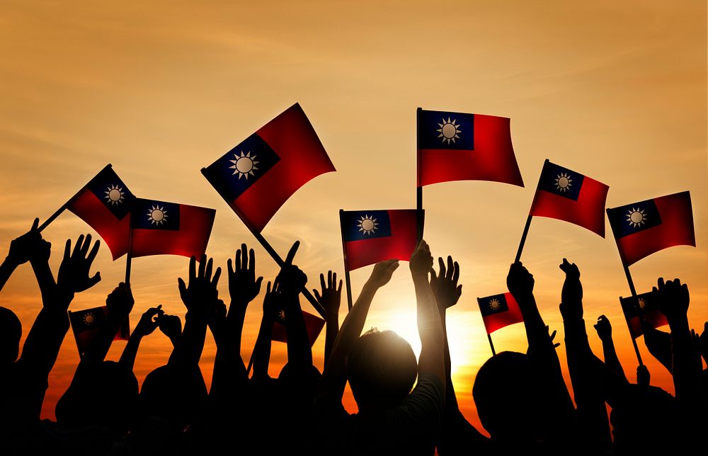 Group of People Waving Taiwanese Flags in Back Lit