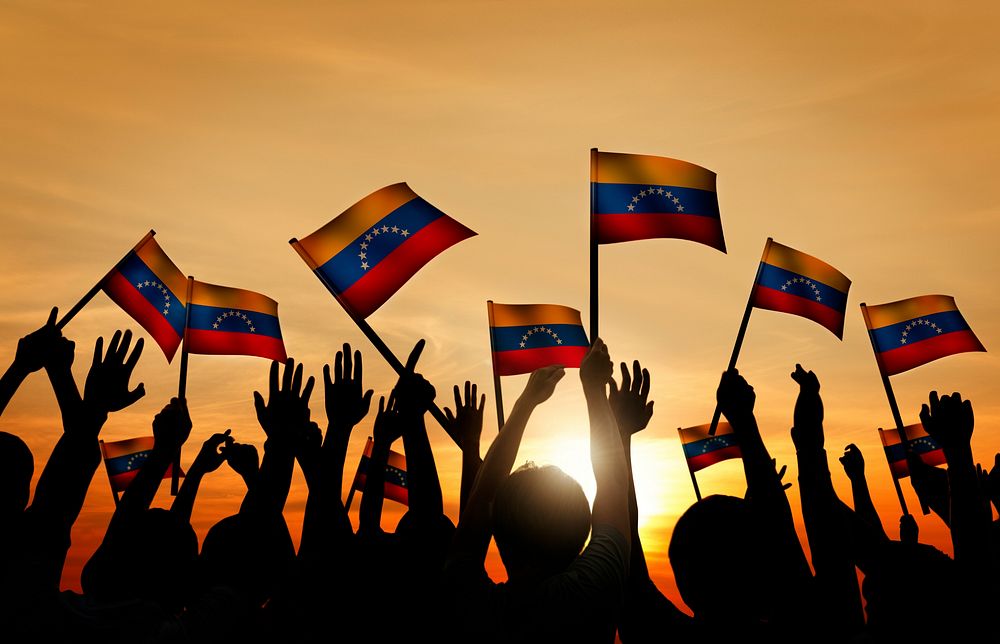 Group of People Waving Venezuelan Flags in Back Lit